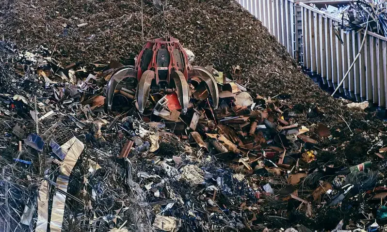 A grab crane working a pile of mixed scrap metal at the yard.