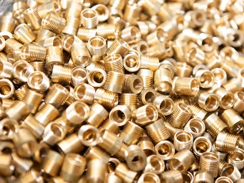 A pile of small brass fittings and threaded inserts collected for weighing.