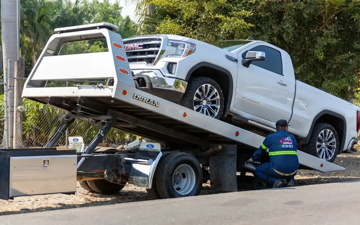 An end of life vehicle being loaded onto a tilt tray truck for scrapping.