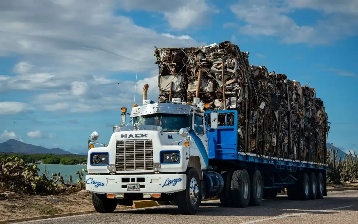 A truck loaded with baled scrap metal on the road after a pickup.