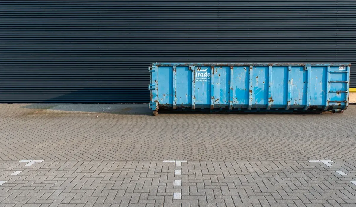 A scrap metal bin dropped beside a building ready to be filled.